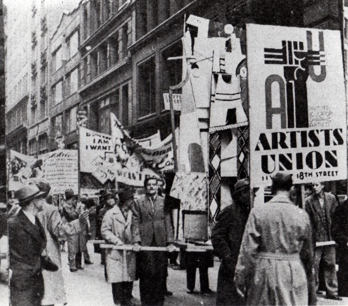 People in a parade with political floats walking down a New York City street with tall stone buildings