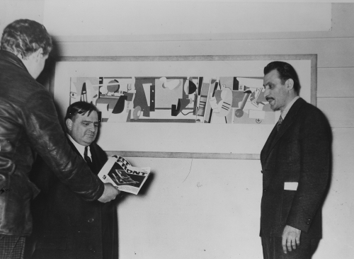 Gorky and Mayor Fiorello H. La Guardia at the opening of the Federal Art Project Gallery, New York, December 27, 1935. The mayor is receiving a copy of the Artists&#39; Union publication&nbsp;Art Front. Frances Mulhall Achilles Library, Whitney Museum of American Art, New York. Visible behind Gorky and La Guardia is Gorky&#39;s&nbsp;Aviation, 1935, a gouache on paper study for his unrealized mural at Floyd Bennett Field, Brooklyn. The goauche study is now lost.&nbsp;[AGCR: D1861]